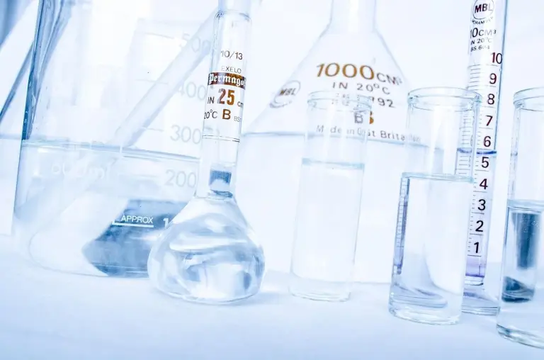 Laborkolben und Messbecher mit klarem Wasser · Zauberwasser