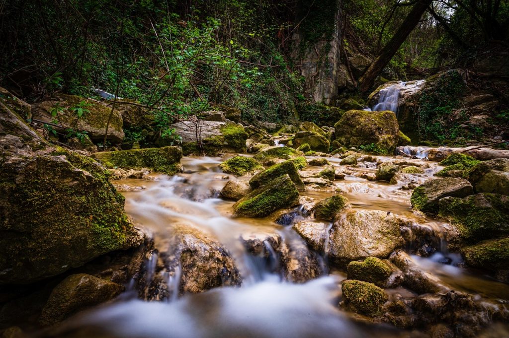 Bergbach mit Wasserfall im Wald — natürliche Wirbelbewegung und Implosion nach Viktor Schauberger