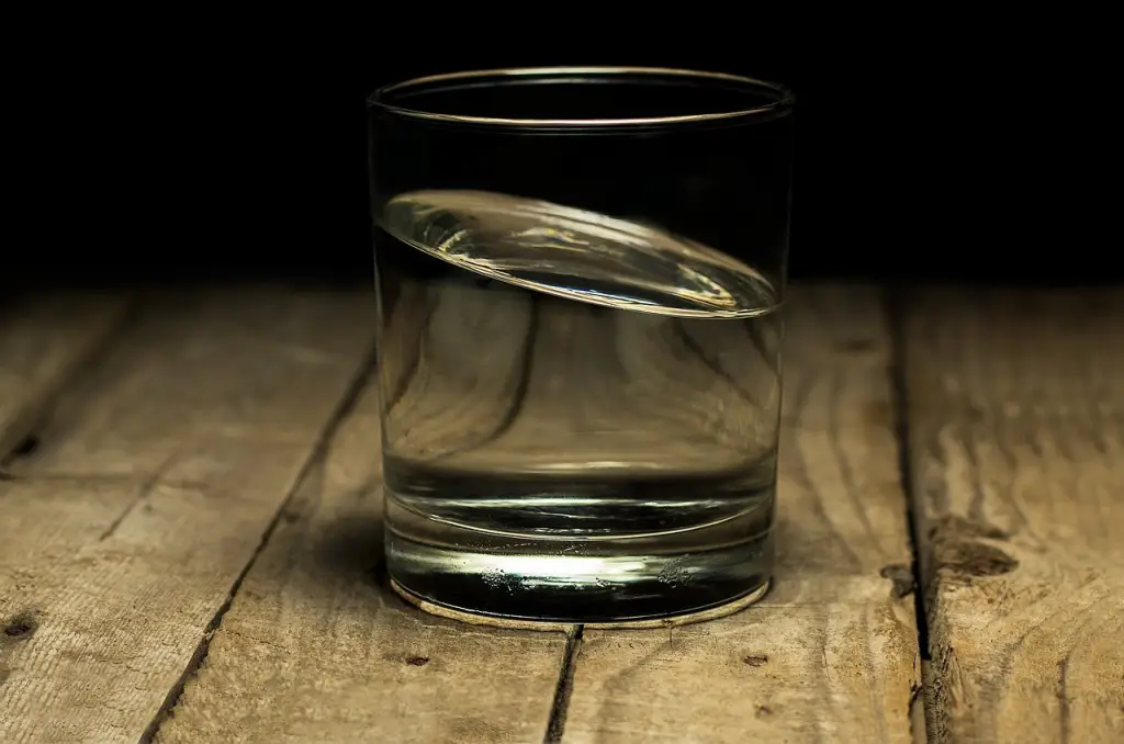 Glas mit klarem Wasser auf einem Holztisch · Zauberwasser